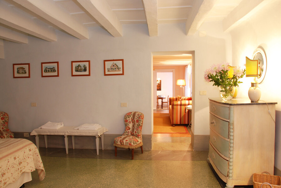 Das Schlafzimmer der Ferienwohnung Il Mezzanino mit geschmackvollen Sesseln und einer Kommode