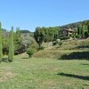 Das Ferienhaus Compignano Barn in der Toskana liegt auf einem grünen Hügel umgeben von Zypressen