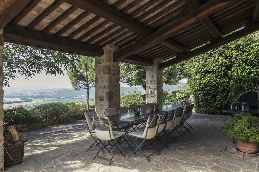 Überdachte Terrasse mit Esstisch und Blick auf die Hügel von Umbrien