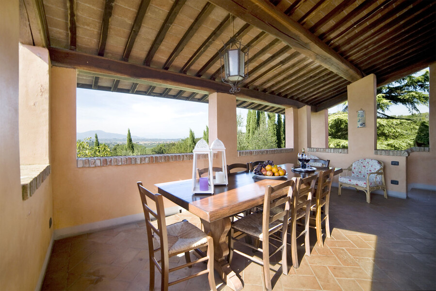 Überdachte Terrasse mit gedecktem Esstisch im Ferienhaus in der Toskana