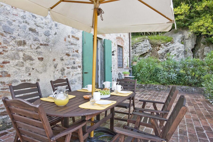 Gartentisch mit Sonennschirm im Ferienhaus casa fiora in der Toskana