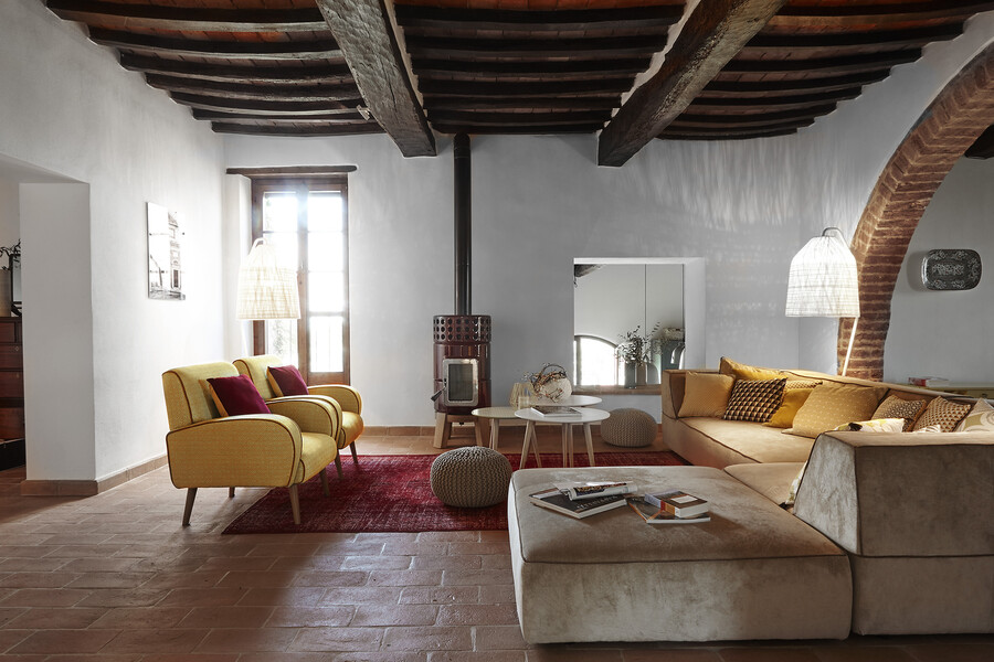 Wohnzimmer mit Retromöbeln und Ofen im Ferienhaus Bellaria in Umbrien