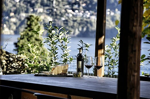 Esstisch im Garten der Villa Crotto mit Weinflasche am Comersee