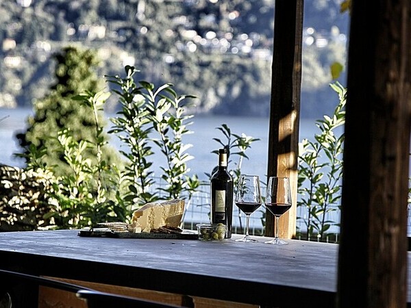 Esstisch im Garten der Villa Crotto mit Weinflasche am Comersee