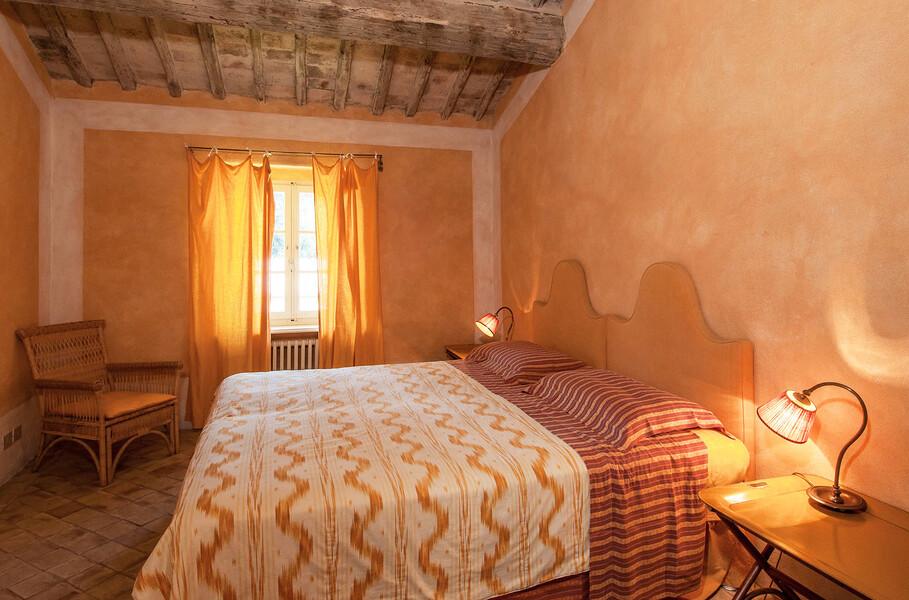 Eine dezente, aber edle Einrichtung und sanfte Farbtöne zeichnen dieses Schlafzimmer der Villa Il Lavacchio aus